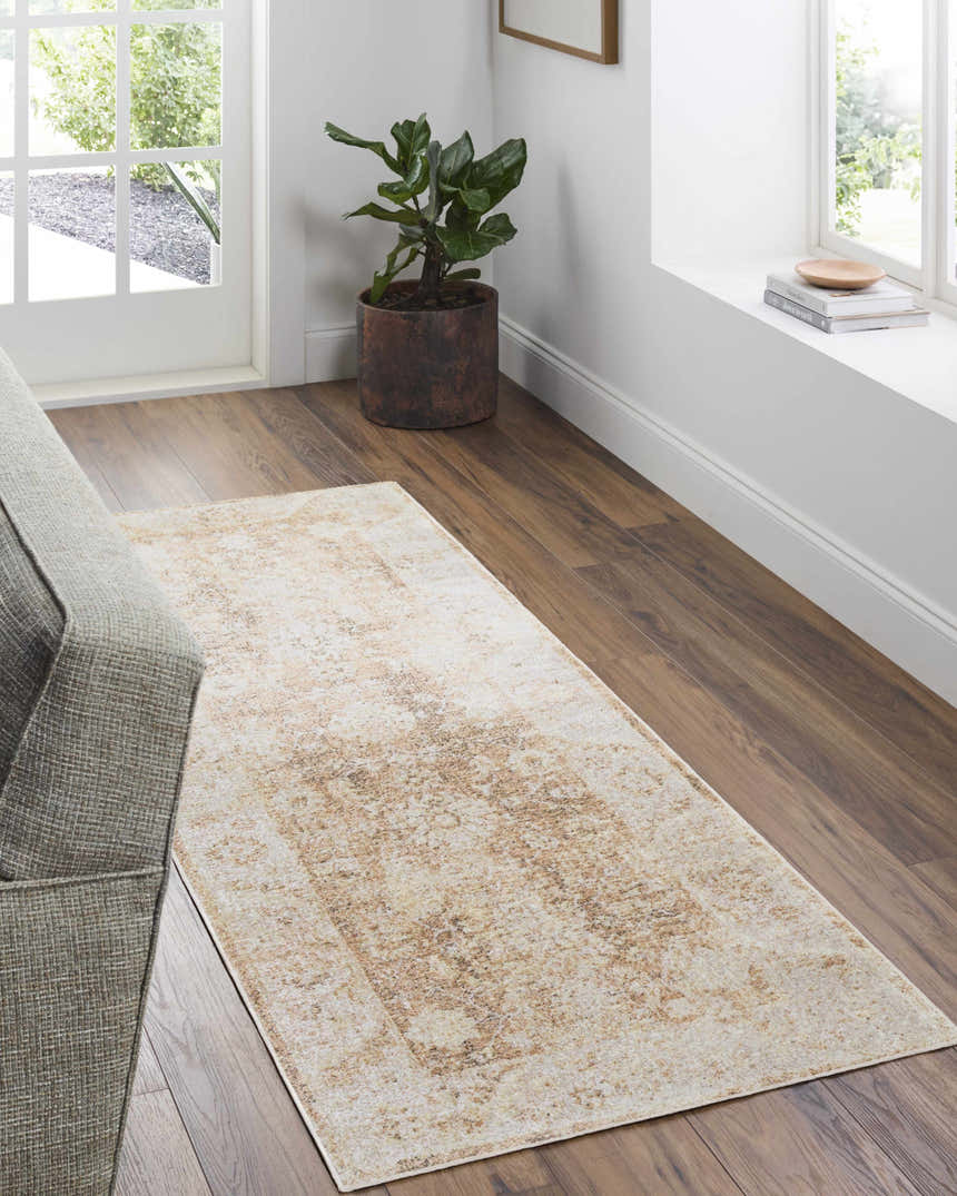 Entryway with a neutral sofa and the tan Aniyah Washable Area Rug on wood floors. Plant and books add warmth. Roomscene-Runner