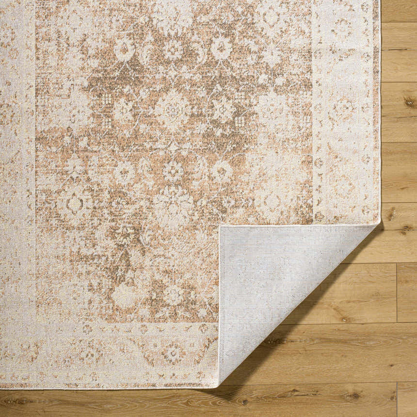 Close-up of the Aniyah Washable Area Rug showing its traditional, farmhouse design in ash, pearl, prairie dust, and tan colors. Fold
