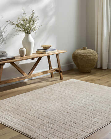 Living room scene with beige Cascade Machine Woven Our PNW Home x LIVABLISS area rug, wood bench, and neutral decor. Roomscene-Rectangle