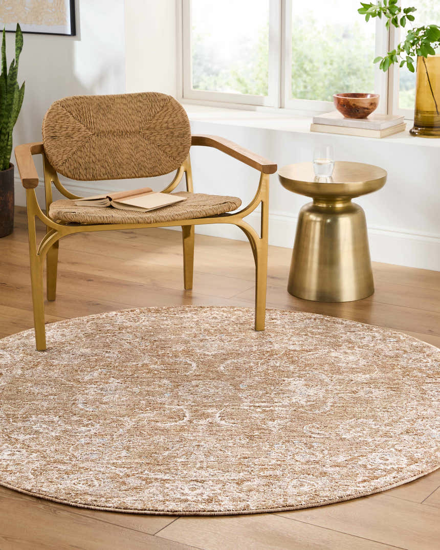 Living room scene with a round Tylie Tan Area Rug, woven chair, and gold side table. Roomscene-Round