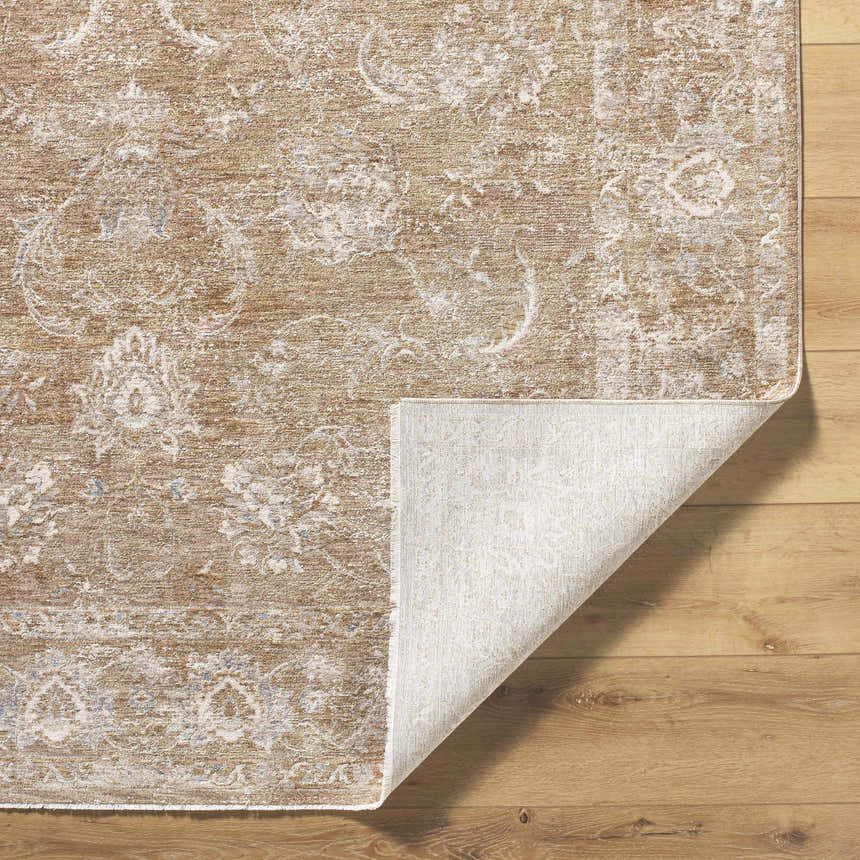 Close-up of the Tylie Tan Area Rug showing its cream, light brown, and olive floral pattern and texture on wood floor. Fold