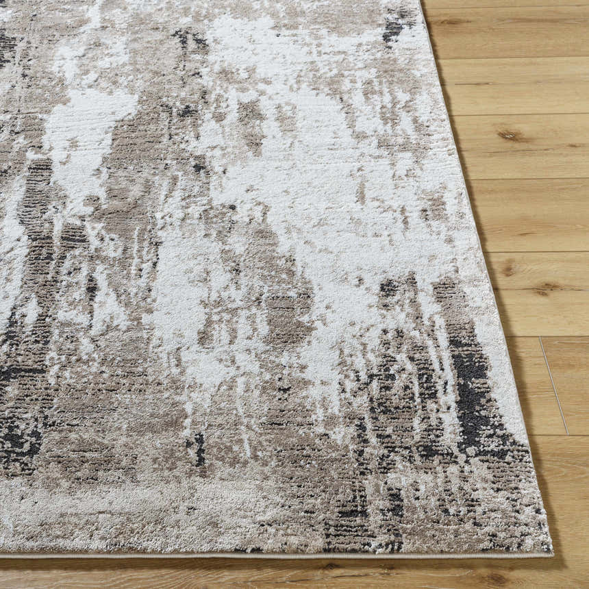 Close up of Taszi Luxe Thick Area Rug showing abstract black, ivory, peach, and tan design on wood floor. Front