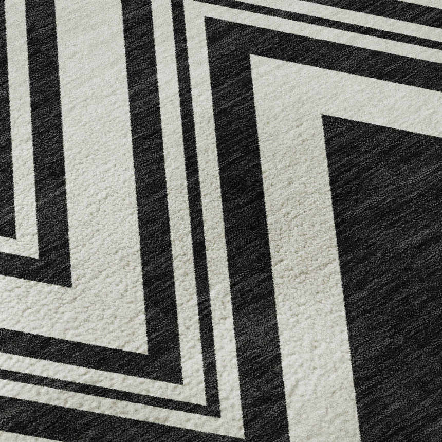 Close-up of the Dalyn Luxury The Reserve TR17 Black Washable Area Rug, featuring a bold black and off-white geometric pattern.