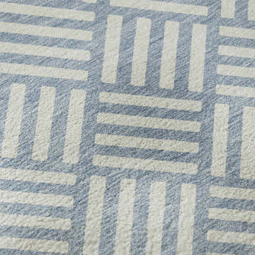 Close-up of Dalyn Luxury The Reserve TR3 Denim Washable Area Rug, showing geometric pattern in denim and white.