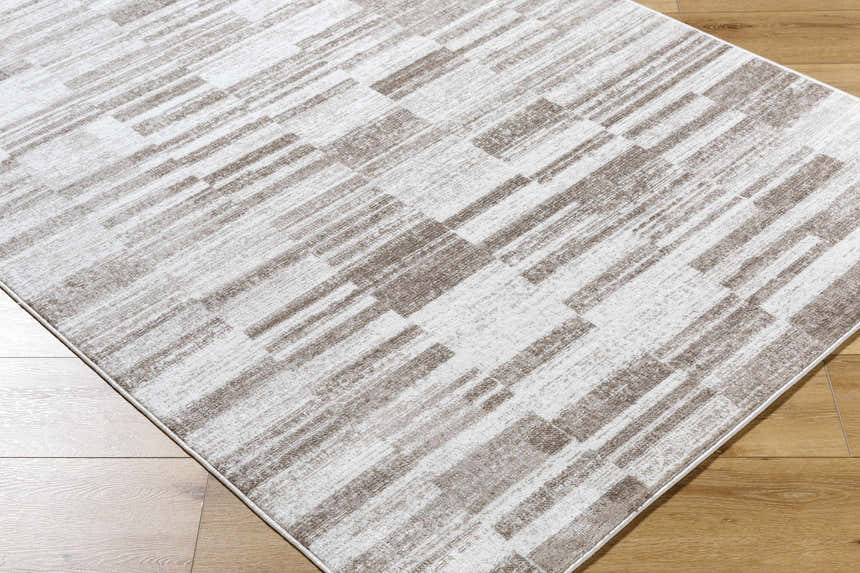 Close-up of the Tehya Beige Area Rug with a contemporary light silver and silver gray geometric pattern. Corner