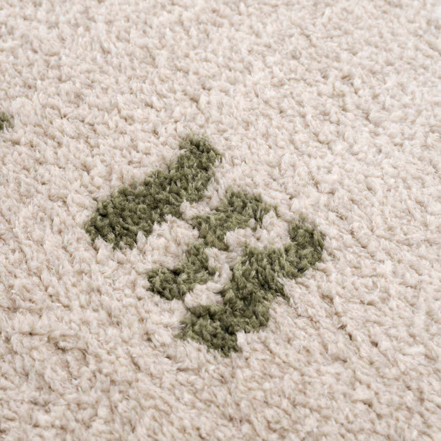 Close up of the Azriel Green Washable Area Rug showing the shag texture and lime green diamond pattern. Texture