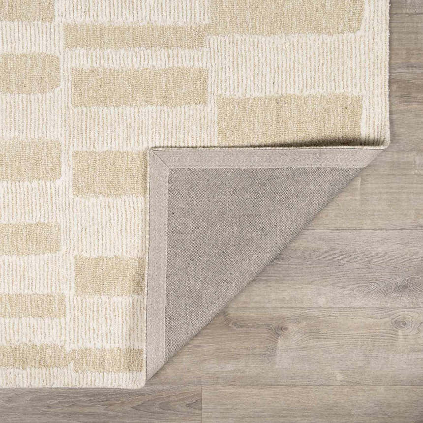 Close up of the Teige Light Silver Area Rug showing its geometric pattern and wool texture. Fold