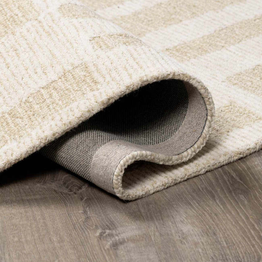 Close-up of the hand-tufted Teige Light Silver Area Rug showing its wool texture, geometric pattern, and durable backing. Fold