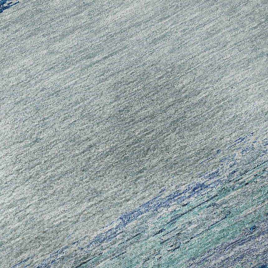 Close-up of the Dalyn Luxury Trevi TV8 Blue Washable Area Rug. Features a textured pattern in denim, light blue, and teal.