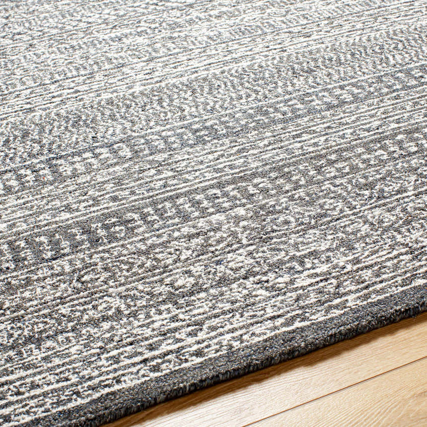 Close-up of the hand-tufted Urvi Area Rug. Gray and smoke wool rug with a subtle Moroccan-inspired stripe pattern. Texture