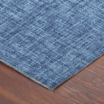 Close-up of the navy Dalyn Luxury Voyage VY1 Washable Area Rug showing woven texture and subtle pattern on a wood floor.