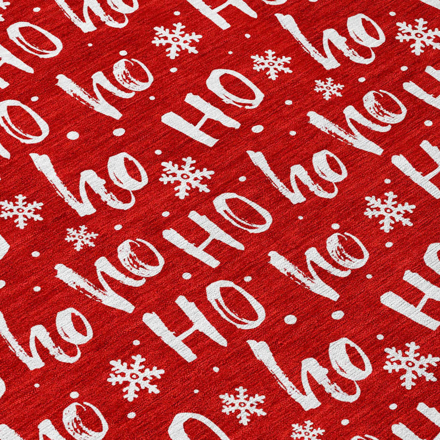 Close-up of the Dalyn Wonderland WN22 Red Washable Area Rug featuring a festive white Ho Ho Ho and snowflake pattern.