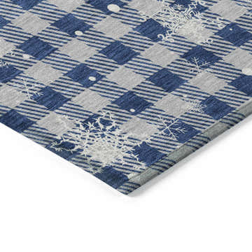 Close-up of Dalyn Wonderland WN32 Blue Washable Area Rug. Features a blue and taupe plaid pattern with white snowflake accents.