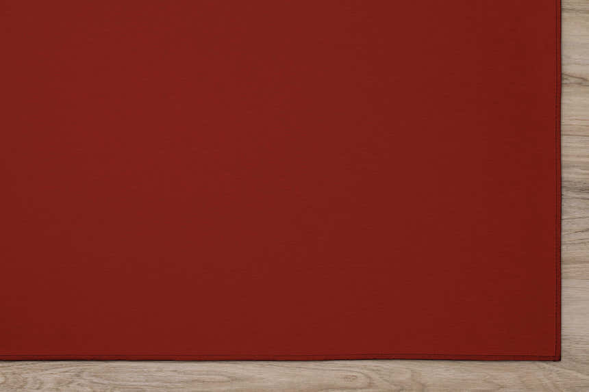 Close-up of the solid red Dalyn Wonderland Washable Area Rug on light wood floor.