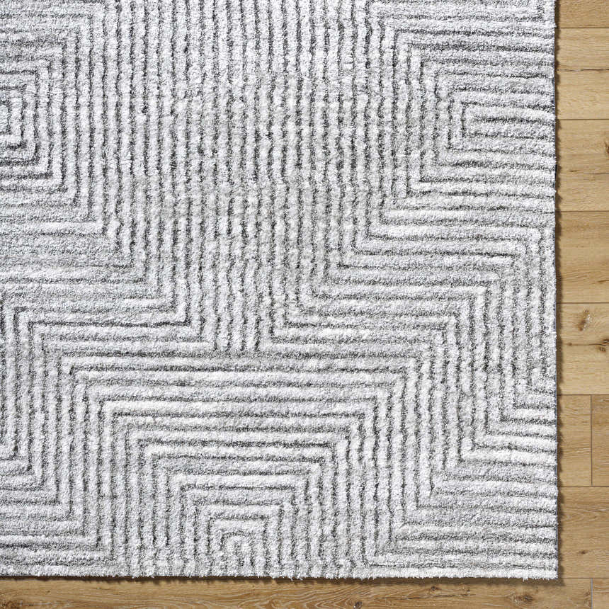 Close-up of the light silver Aerith Shag Area Rug, featuring a geometric pattern and soft, plush texture. Swatch