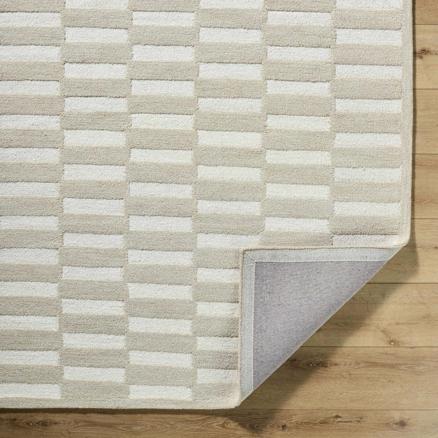 Close-up of the Uther Area Rug. Beige and ivory wool rug with a contemporary rectangular block pattern. Fold
