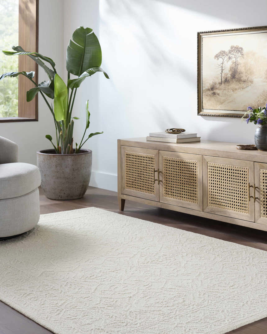 Living room scene with a Yadid Cream Wool Area Rug, light wood cabinet, gray chair, and large potted plant. Roomscene-Rectangle