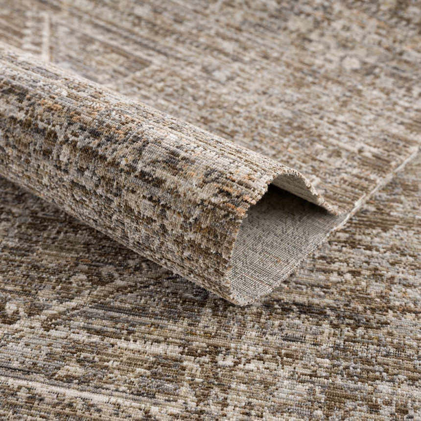 Close-up of the brown and sage Yamir Washable Outdoor Rug, showing the traditional vintage pattern and soft texture. Fold