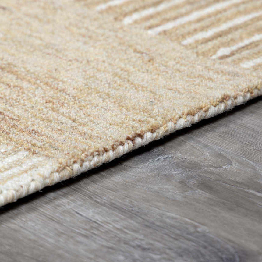 Close-up of the hand-tufted Yoyko Area Rug. Ash, pearl, prairie dust, and tan wool rug with subtle geometric pattern. Pile