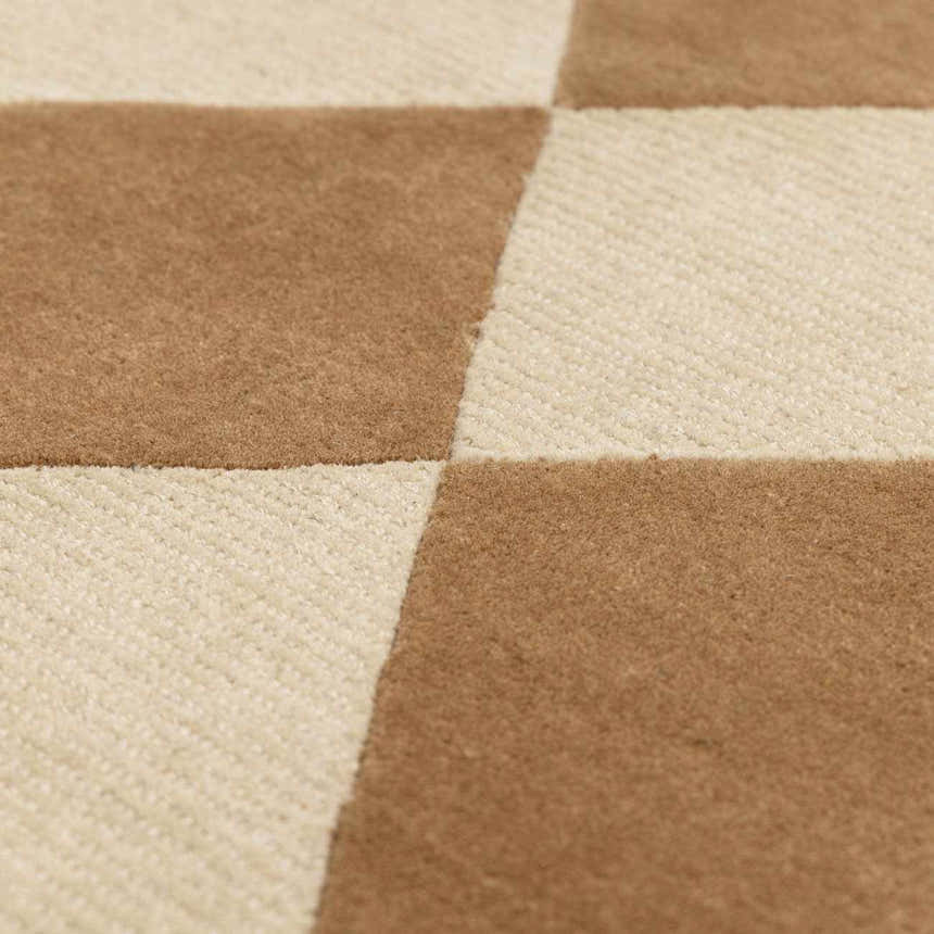 Close up of the Aradia Tan Area Rug showing a checkerboard pattern in tan and cream wool. Texture