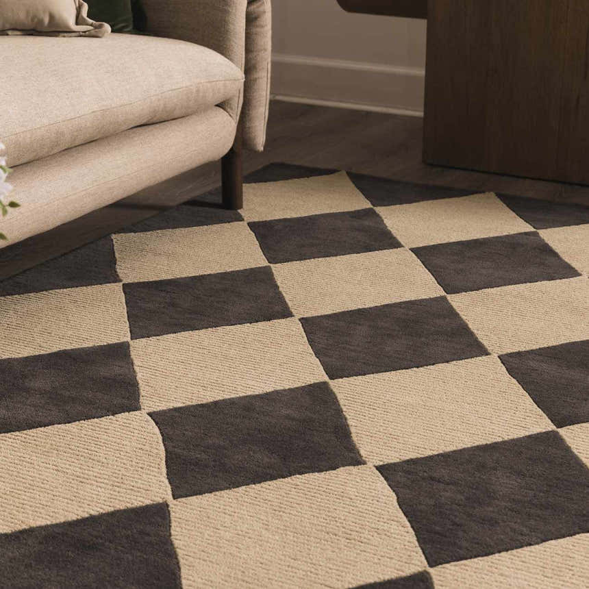 Close-up of the hand-tufted Aradia Charcoal Area Rug, a wool rug with a contemporary checkerboard pattern. Roomscene-Rectangle