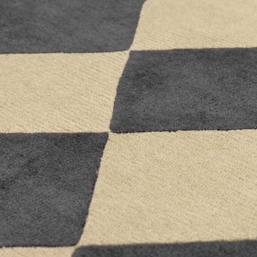Close-up of the Aradia Charcoal Area Rug. Hand-tufted wool rug with a contemporary checkerboard pattern in charcoal and beige. Texture