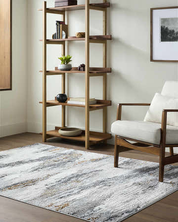 Living room scene with a Zelia Area Rug in charcoal, brown, and white, styled with a wooden shelf and chair. Roomscene-Rectangle
