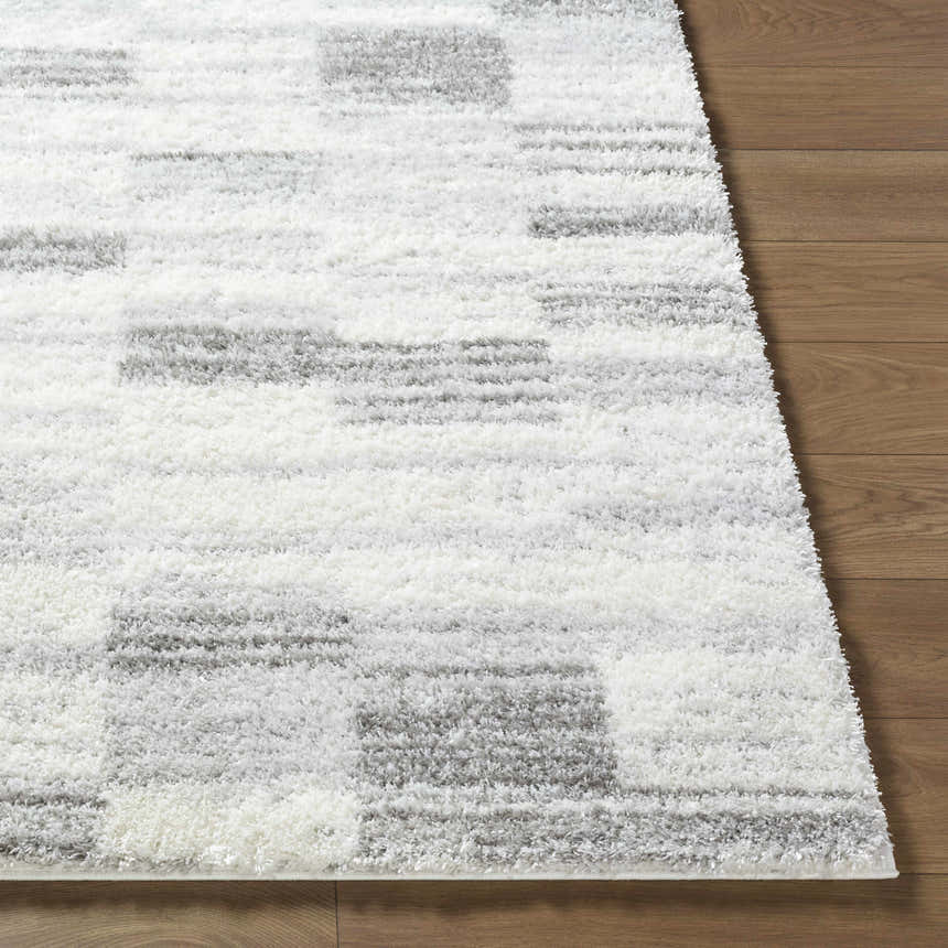 Close-up of the ivory and peach Alaura Area Rug, a contemporary shag with a geometric pattern and soft texture. Front