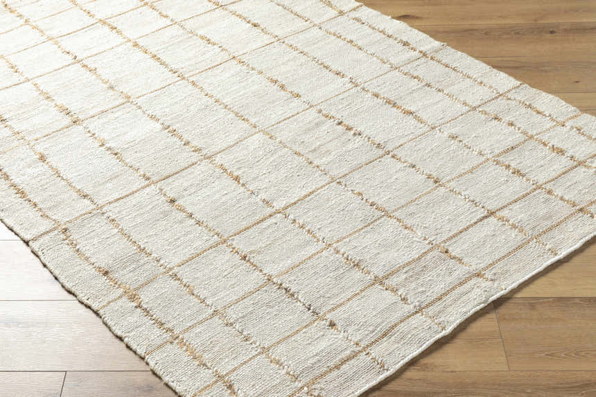 Close-up of the hand woven Zared Checkered Jute Area Rug. The rug is ash and light silver with a farmhouse style. Corner