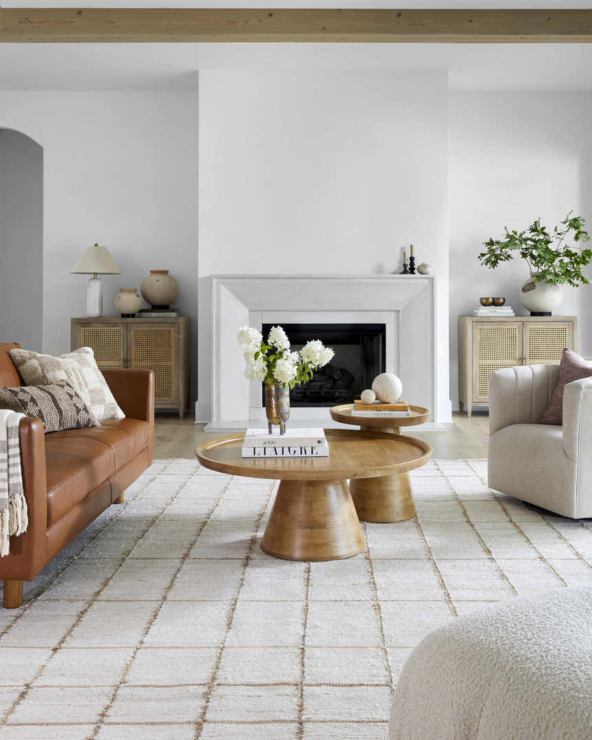 Living room with a Zared Checkered Jute Area Rug, brown leather sofa, and light wood coffee tables. Roomscene-Rectangle