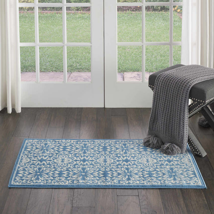 Entryway with Nourison Jubilant Ivory Blue Farmhouse Indoor Area Rug, dark wood floor, bench, and white french doors.
