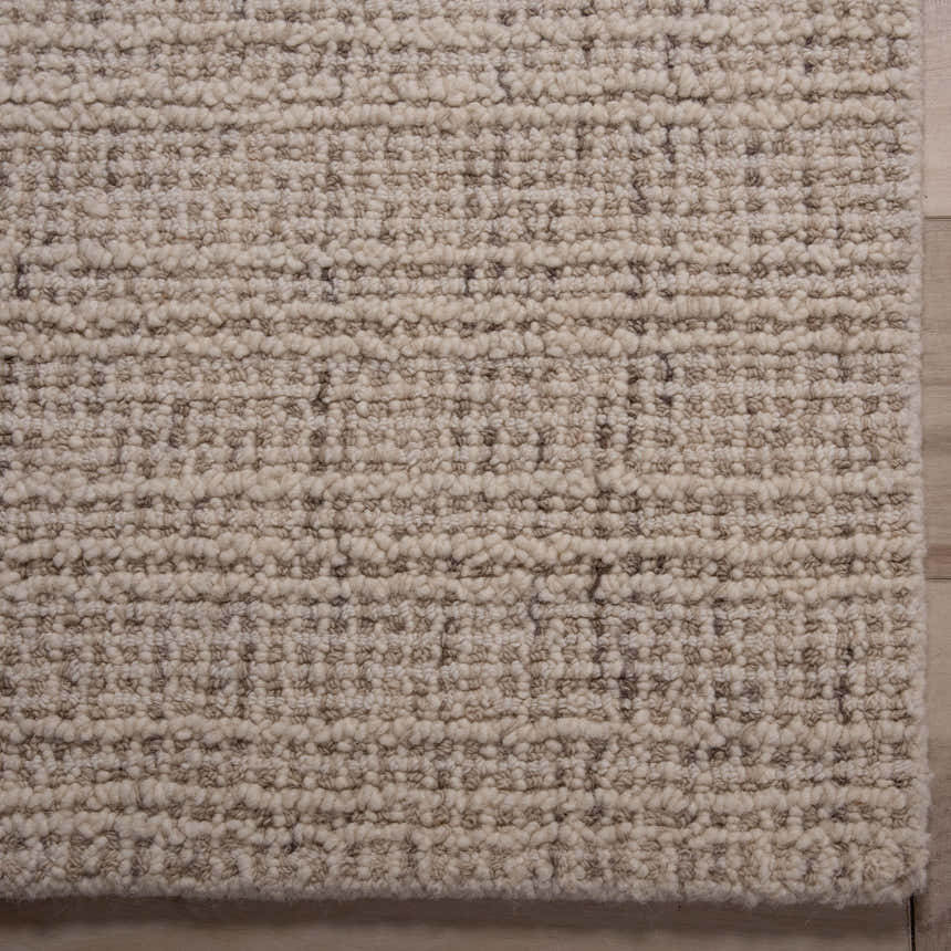 Close up of the hand tufted Rizzy A07203 area rug. Ivory and dark red wool rug with a textured, contemporary design. Corner