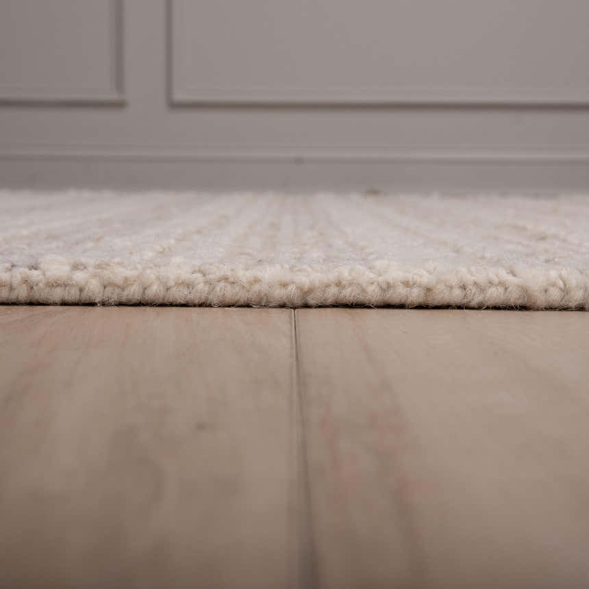 Close-up of the ivory Rizzy A07203 area rug showing its wool texture and hand-tufted construction. Pile