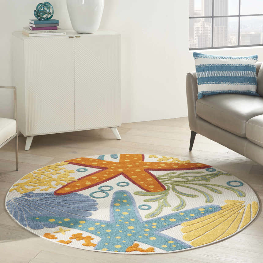 Coastal living room with a Nourison Aloha Multicolor area rug featuring starfish and seashell designs.