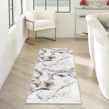 Living room scene with Inspire Me! Home Decor Daydream rug. Ivory, chestnut, and gold marble pattern. Modern chair and sofa.