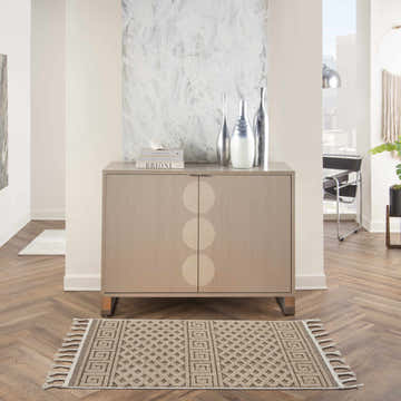 Hallway scene with a Nourison Paxton Mocha rug, wood floors, and a modern cabinet with vases.