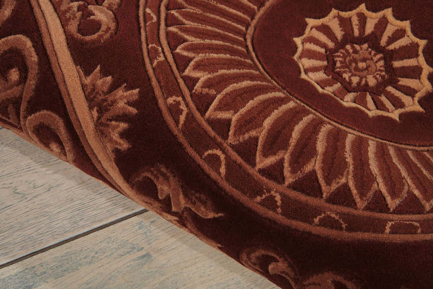Close-up of the brick red Nourison Versailles Palace rug, showing the floral medallion pattern and wool texture.