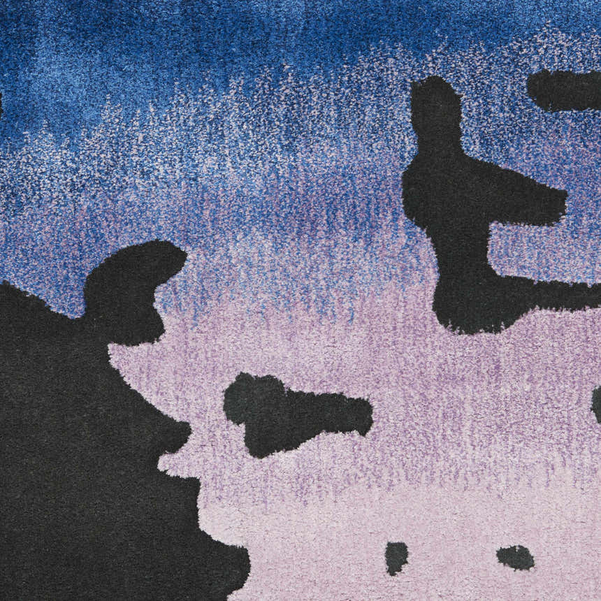 Close-up of the Nourison Prismatic Black Multicolor rug showing its abstract design, blue, lilac, and black colors, and soft texture.