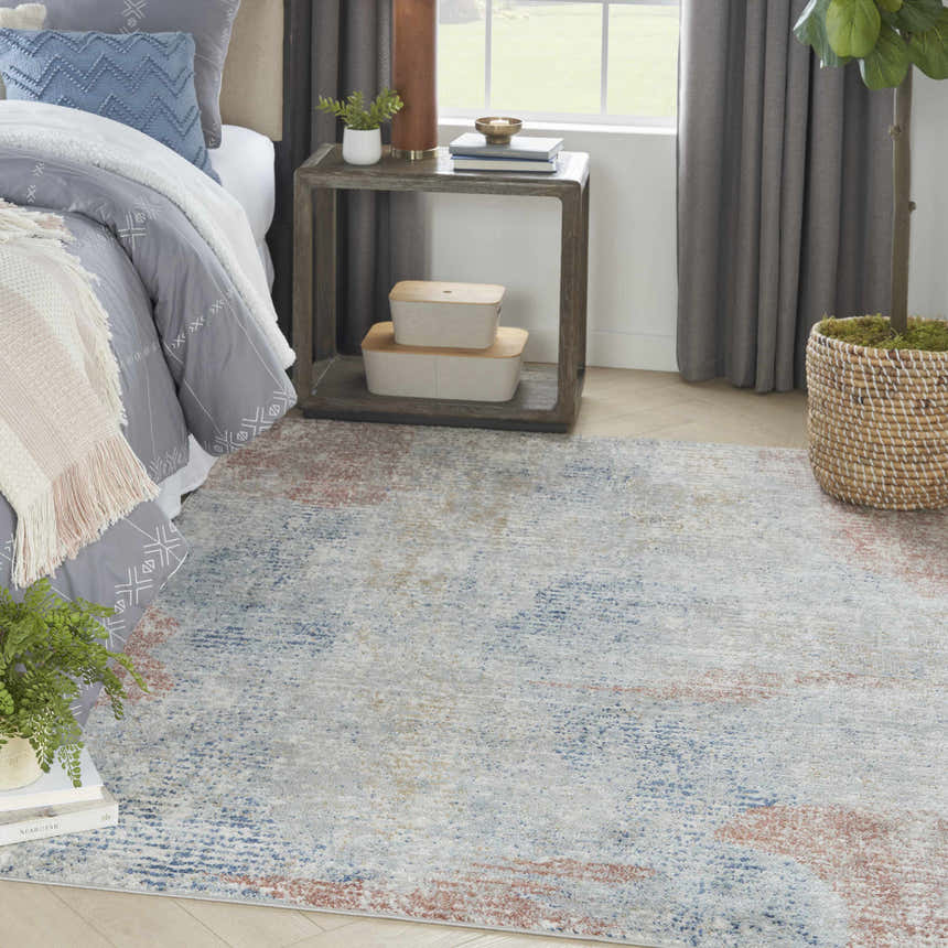 Bedroom scene with Nourison Quarry Ivory Multicolor rug, gray bedding, and wood side table.