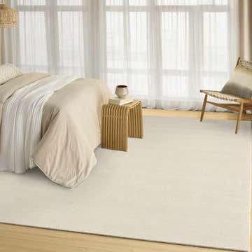Light and airy bedroom scene with DKNY Pure Rows Ivory Farmhouse Indoor Area Rug, wood furniture, and neutral bedding.