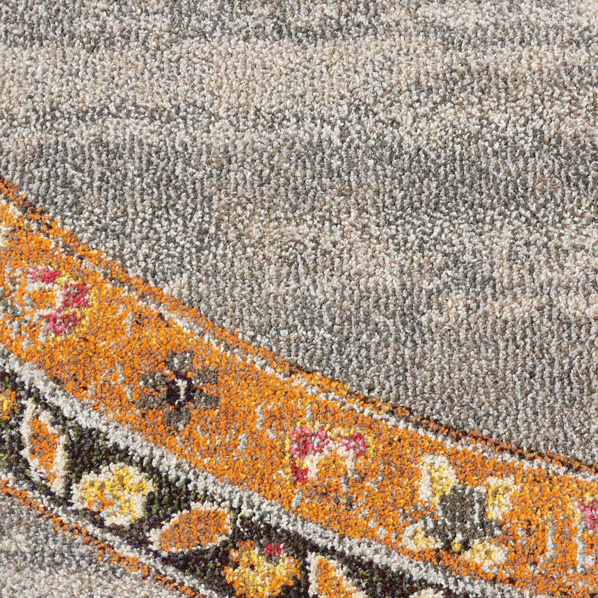 Close-up of Nourison Passionate Grey Bohemian rug. Features gray, orange, yellow, and red floral accents. Soft texture.
