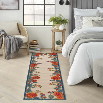 Bedroom scene with Nourison Aloha Ivory Multicolor runner rug, floral pattern, wood floors, and neutral decor.