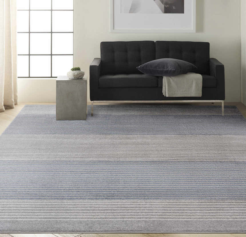 Modern living room with a grey sofa and Calvin Klein River Flow Grey area rug.
