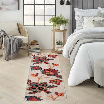 Bedroom scene with a Nourison Aloha Multicolor runner rug featuring a vibrant floral pattern.