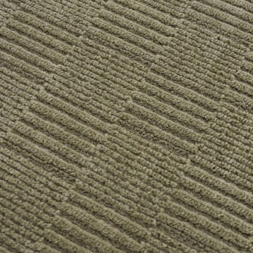 Close-up of the Kazuma Green Washable Area Rug showing its ridged texture and gray green color. Texture