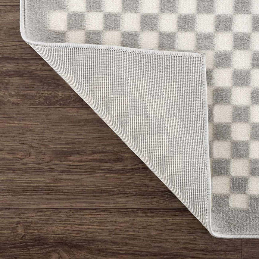 Close-up of the Gaiwan Cream Gray Washable Area Rug showing its checkerboard pattern and non-slip backing. Fold