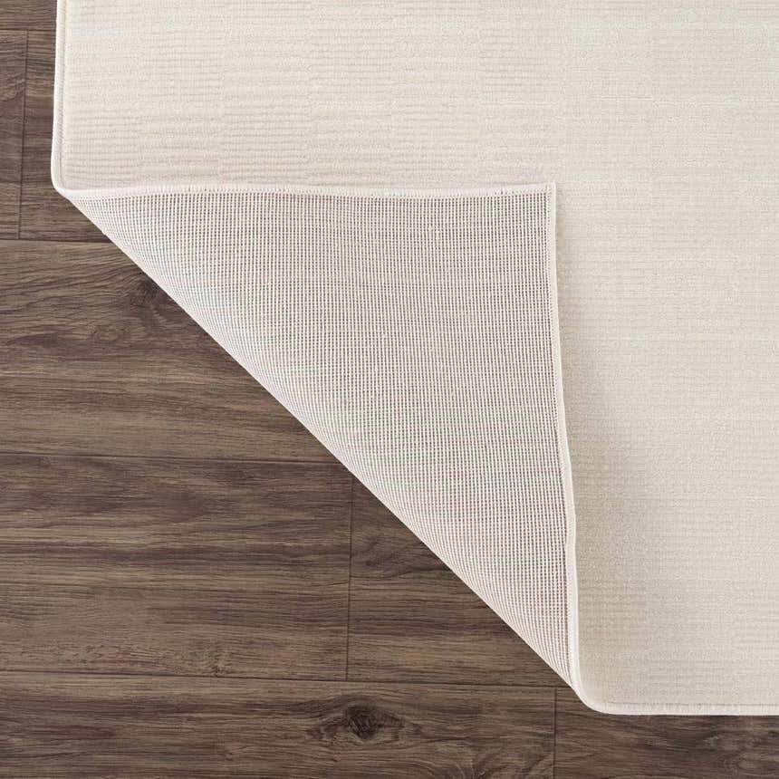 Close-up of the Kazuma Cream Checkered Washable Area Rug showing the cream color, subtle checkered pattern, and non-slip backing. Fold