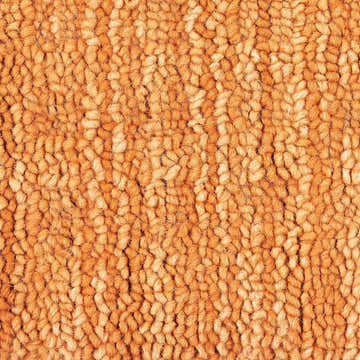 Close-up of the handmade Nourison Marana Sunset rug, showcasing its wool texture and sunset orange color.