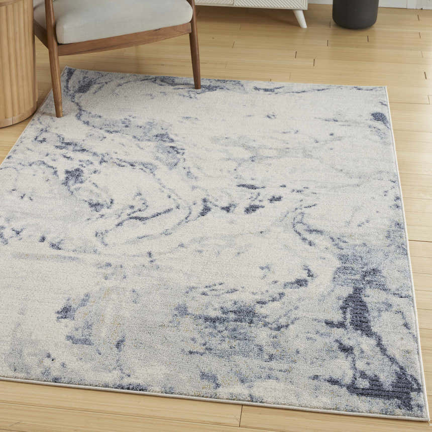 Modern living room scene with a Nourison Motion Ivory Blue area rug, light wood floors, and neutral furniture.