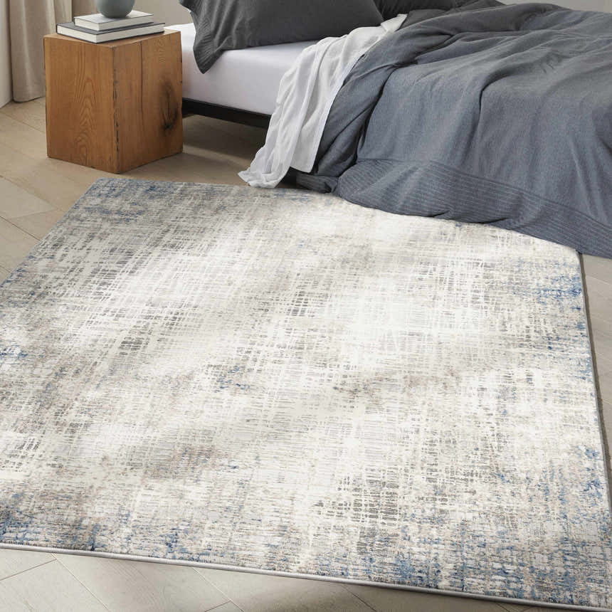 Modern bedroom with a Calvin Klein CK022 Infinity Blue Multicolor rug, wood nightstand, and gray bedding.